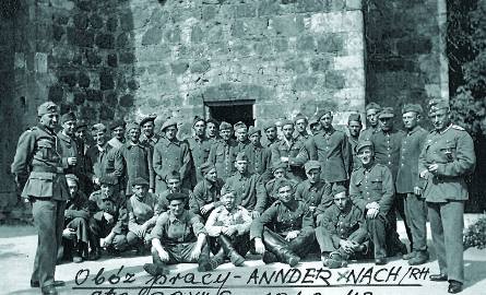 Polscy i francuscy jeńcy w obozie pracy w miejscowości Annder nad Renem. W tle wieża, w której mieszkali jeńcy. Pan Roman siedzi pierwszy z prawej (dłonie