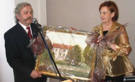 Burmistrz Andrzej Jarzyński ofiarował prezes Grażynie Łubie obraz przedstawiający zamek w Szydłowcu