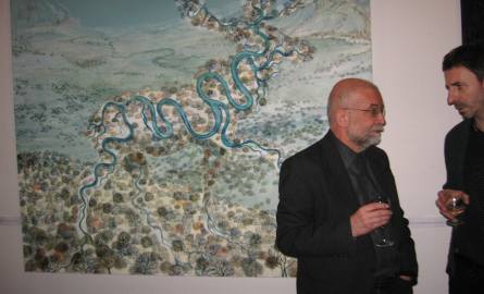 Mieczyslaw Szewczuk z Muzeum  Sztuki Współczesnej stoi pod obrazem o barwie nieba