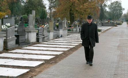 Cześć cmentarza za nową bramą została wybrukowana – pokazuje ksiądz Andrzej Tuszyński