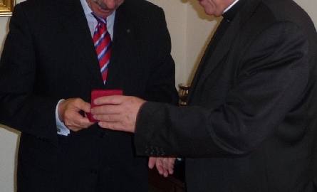 Arcybiskup Zygmunt Zimowski, przewodniczący Papieskiej Rady do spraw Duszpasterstwa Służby Zdrowia wręcza doktorowi Góździowi medal Miłosierny Samar