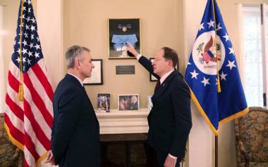 Ambasador Mark Brzezinski wskazuje na medale otrzymane przez jego ojca Zbigniewa Brzezińskiego od prezydentów USA oraz Polski