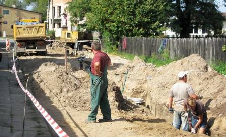 Trwają prace przy budowie kanalizacji deszczowej w ulicy Kościelnej, za bramką.