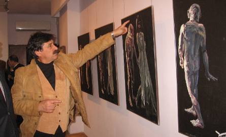 Jacek Szpak pokazuje obrazy Leszka Sobockiego.