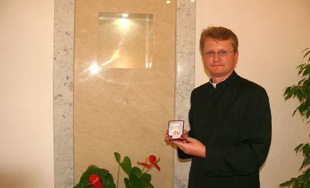 Ksiądz Mariusz Kozłowski z relikwiami papieża przy ołtarzu bocznym, gdzie będą zainstalowane.