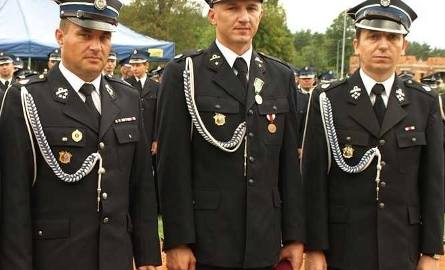Wicewojewoda świętokrzyski Grzegorz Dziubek (z lewej) z wójtem Kluczewska Rafałem Pałką (z prawej) oraz Mariuszem Majeckim – strażakiem odznaczonym medalem