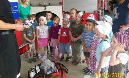 Przedszkolaki jak zaczarowane patrzyły na strażaka, który prezentował wyposażenie wozu strażackiego.