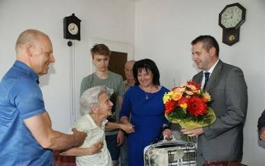 Delegacja Urzędu Miasta i Gminy Chmielnik z burmistrzem Pawłem Wójcikiem na czele składa jubilatce z Piotrkowic kwiaty i życzenia