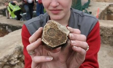Nina Glińska prezentuje kamień z tajemniczą pieczęcią znaleziony tuż obok chaty.