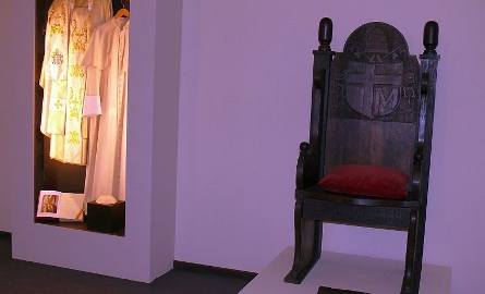 Replika tronu z czarnego dębu, na którym siedział Papież, oraz biała sutanna z pelerynką i piuska.