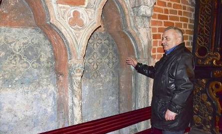 Wojciech Wichnowski pokazuje kamienne średniowieczne siedziska z ciekawością podziwiane przez zwiedzających