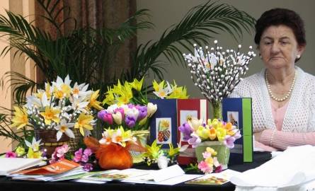 Jadwiga Biała z klubu seniora "Łojewianie" z Łojewa prezentuje misternie wykonane przez seniorów kwiaty, karty świąteczne