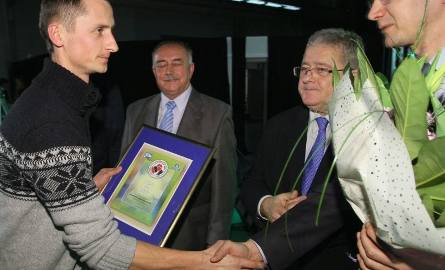 Łukasz Sałek z gospodarstwa agroturystycznego U Zosi odbierał nagrodę za zajęcie pierwszego miejsca w powiecie ostrowieckim z rąk (od prawej) marszałka