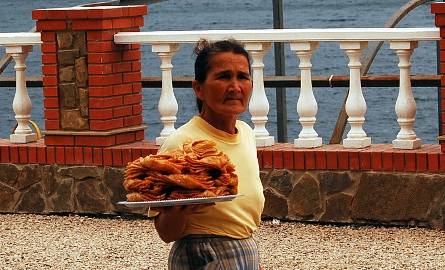 Warto kosztować krymskich smakołyków. Na zdjęciu kobieta z tacą pełną pysznej paklawy.