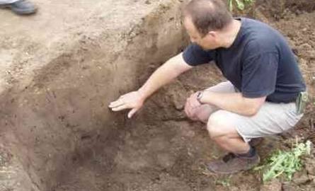 Dr Szymon Orzechowski pokazuje, jak należy kopać.