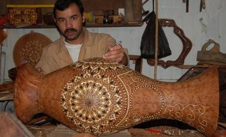 Rzemieślnik pokazuje, jak wyrabia się drewniane mozaiki.
