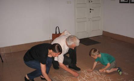 Częscia instalacji jest też pisanie kredą na podłodze -  cieszy się bardzo z tej sztuki pięcioletni  Bruno Olszewski