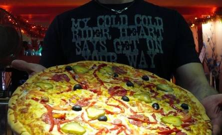 Piotr Piętowski, właściciel pizzerii Trattoria przy ulicy Maciejowskiego w Sandomierzu prezentuje jedną z 28 pizz, którą można zamówić na dowóz.