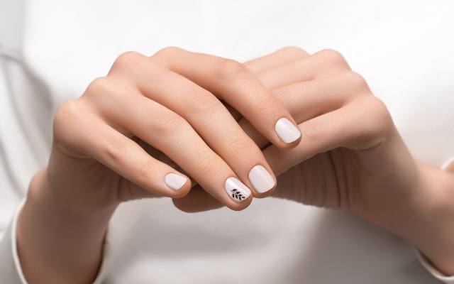 Jesienne paznokcie, które spodobają się minimalistkom i fankom quiet luxury. Pazurki w kolorze kokosowego mleka pięknie wyglądają na dłoni