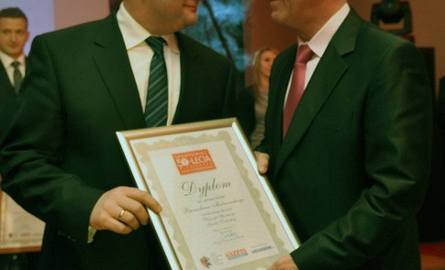 Robert Malinowski odbiera nagrodę w imieniu brata z rąk marszałka Piotra Całbeckiego.