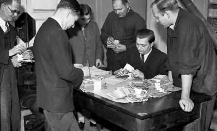 Na zdjęciu wymiana pieniędzy w roku 1950. Fotografia ma charakter propagandowy, nie oddaje rozpaczy ludzi, którzy w ramach tej operacji tracili lwią
