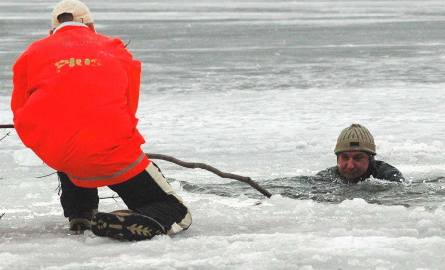 Woprowcy z Choszczna pokazują w jaki sposób należy udzielić pomocy osobie, pod którą załamał się lód: przy pomocy kija...