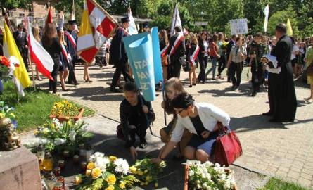Pod pomnikiem świętego Jana Pawła II uczniowie składali kwiaty w kolorach flagi papieskiej.