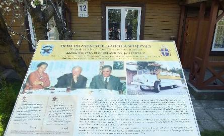 Przed domem umieszczono tablicę informacyjną ze zdjęciami i notatką informującą, że w domu przy ulicy Konstytucji 12 w Starachowicach kilkanaście razy