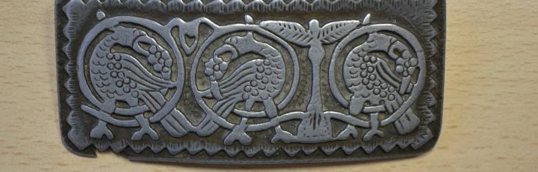 Współczesna skandynawska kopia wikińskiej ozdoby, po lewej od środka między dwoma ptakami (orły? kruki?) widoczny Irminsul.