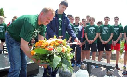 Trener Renisław Dmochowski wraz z młodymi siatkarzami składa wieniec na grobie śp. Arkadiusza Gołasia.