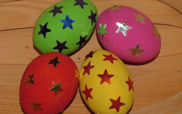 Najmłodsze dzieci pokolorowane przez osobę dorosłą jajka mogą dekorować gotowymi naklejkami.