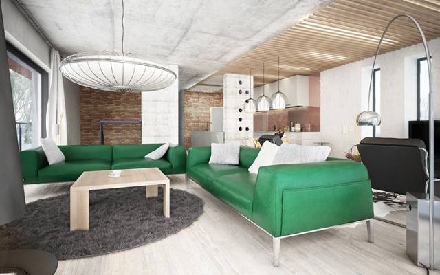 Wnętrze stylizowane na loft, w którym szarość betonu przełamana jest zielenią mebli wygląda bardzo optymistycznie.