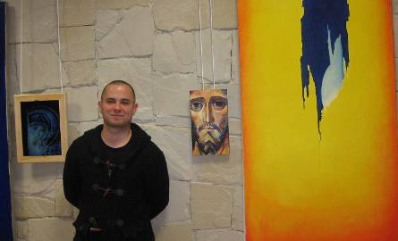 Łukasz Fałdrowicz obok swouch obrazów na wystawie w Fili numer 6.