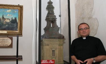 Ojciec Wojciech obok makiety wieży, która wieńczyła niegdyś kościół na Świętym Krzyżu.