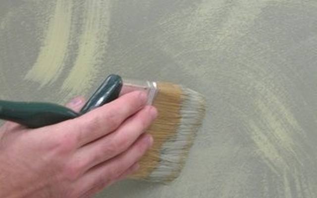 Zamaszystymi ruchami dłoni nanosimy na ścianę niewielką ilość farby.