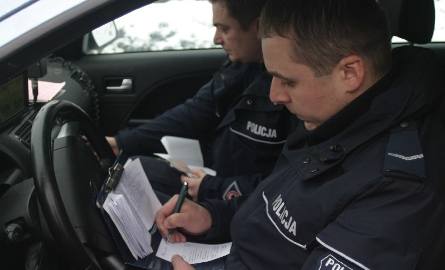 Sierżanci Mariusz Gaborek i Łukasz Bukowski wypisują mandat mężczyźnie, który jechał audi s8 bez ważnego dowodu rejestracyjnego.
