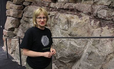 Doktor Anna Żylińska przy kamiennej ścianie auli.