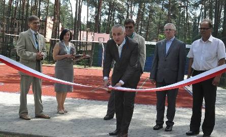 Symboliczne przecięcie wstęgi przy nowym wielofunkcyjnym boisku w Sielpi. Na zdjęciu burmistrz Michał Cichocki (przecina wstęgę) oraz od lewej wicestarosta