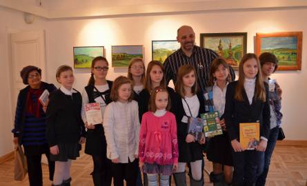 Nagrodzona grupa dzieci z Mazowszan a w środku pisarz, Kazimierz Szymeczko