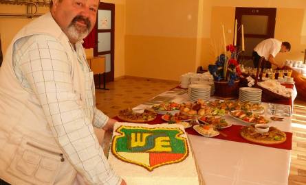 Jerzy Augustyn, przedstawiciel pracowników administracji prezentuje tort, jaki uczelnia dostała od wójta gminy Pysznica.