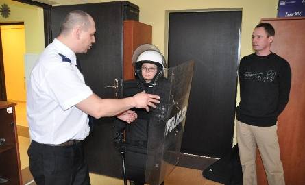 Podkomisarz Mariusz Świeca pomógł Świtoniowi-juniorowi przyodziać ubiór policjanta z prewencji. Przyglądał się temu tata chłopca (z prawej).